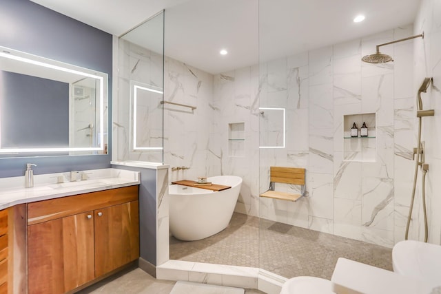 bathroom with a marble finish shower, a freestanding tub, vanity, and toilet