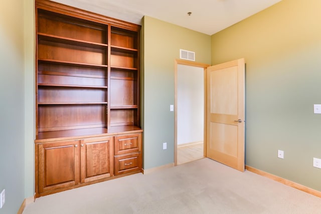 unfurnished bedroom with carpet, visible vents, and baseboards