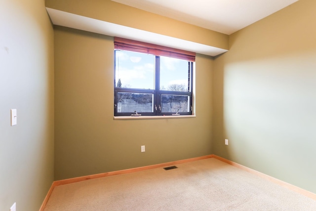 carpeted spare room with baseboards and visible vents