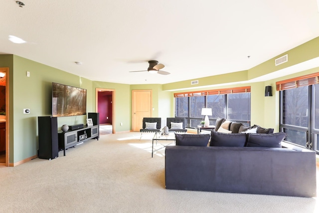 living area with a healthy amount of sunlight, visible vents, and light colored carpet