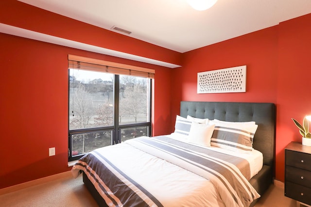 bedroom with baseboards, visible vents, and carpet flooring