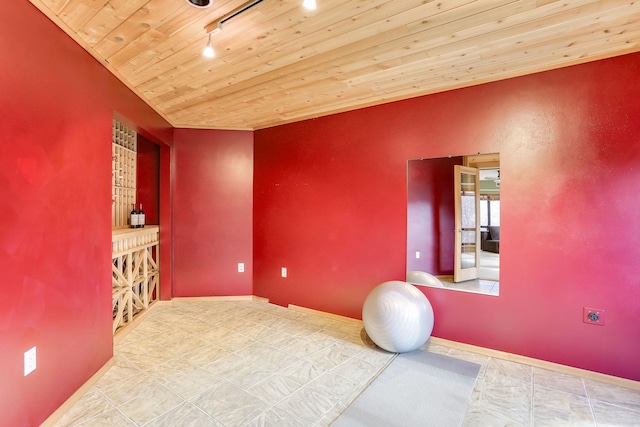 exercise area featuring wooden ceiling, baseboards, and track lighting