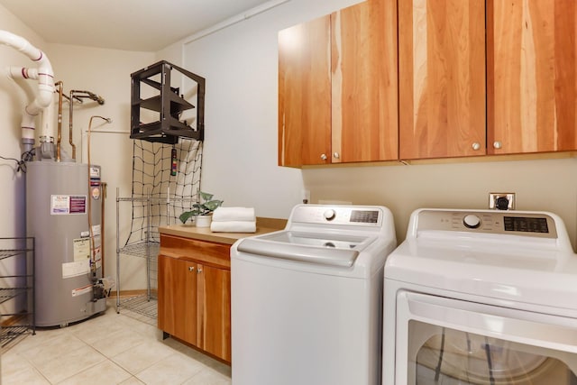 laundry area featuring water heater, cabinet space, washing machine and clothes dryer, and light tile patterned flooring