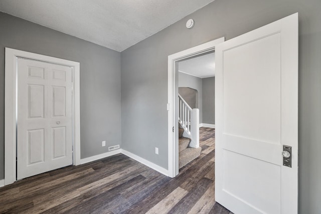 empty room featuring dark wood-type flooring and a textured ceiling