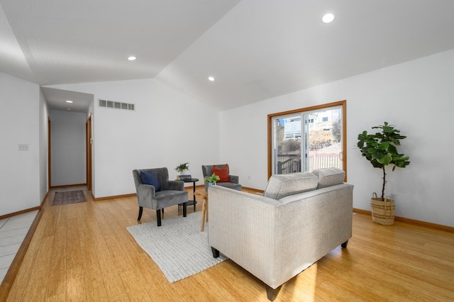 living room featuring vaulted ceiling and light wood-type flooring