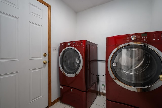 laundry area with light tile patterned flooring and washer and clothes dryer