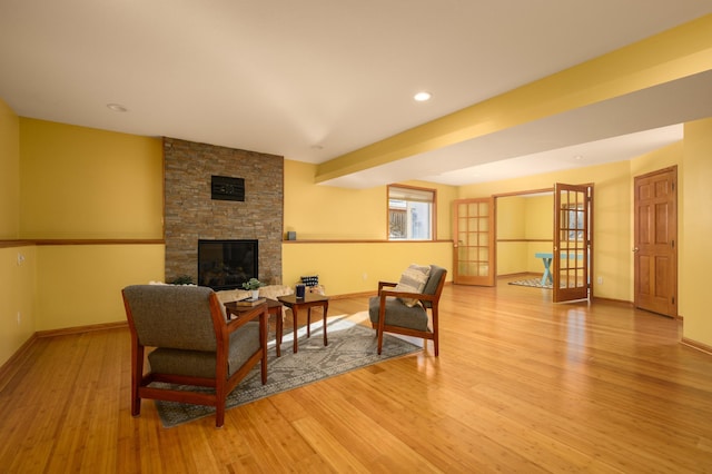 living room featuring french doors, a fireplace, and light hardwood / wood-style flooring