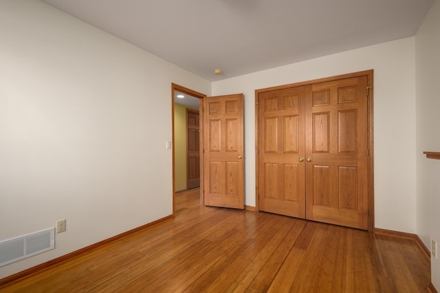 unfurnished bedroom with a closet and light wood-type flooring