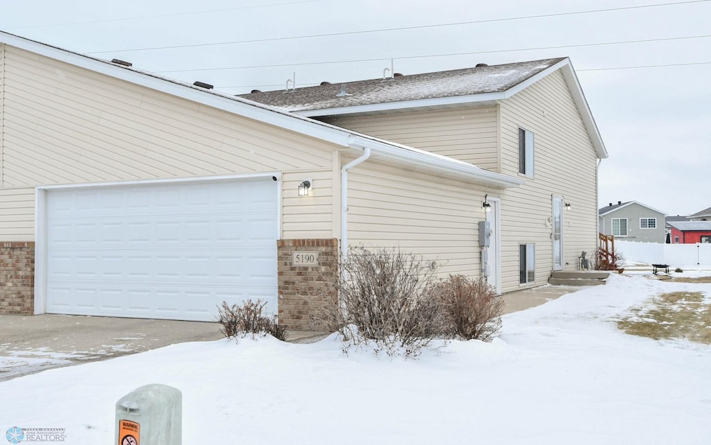 snow covered property featuring a garage