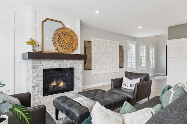 living room featuring recessed lighting, a fireplace, baseboards, and wood finished floors