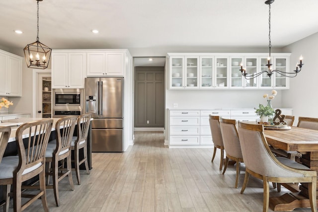 dining area featuring recessed lighting, a notable chandelier, and light wood finished floors