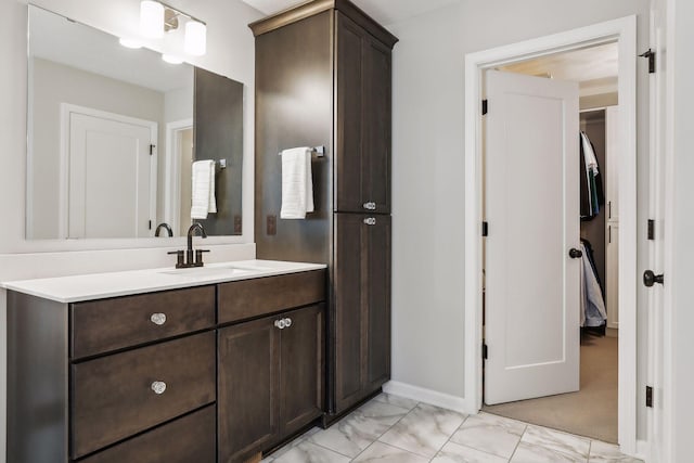 bathroom featuring marble finish floor, vanity, and baseboards