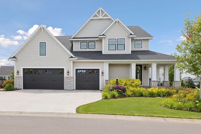 craftsman house featuring driveway, a front lawn, roof with shingles, and an attached garage