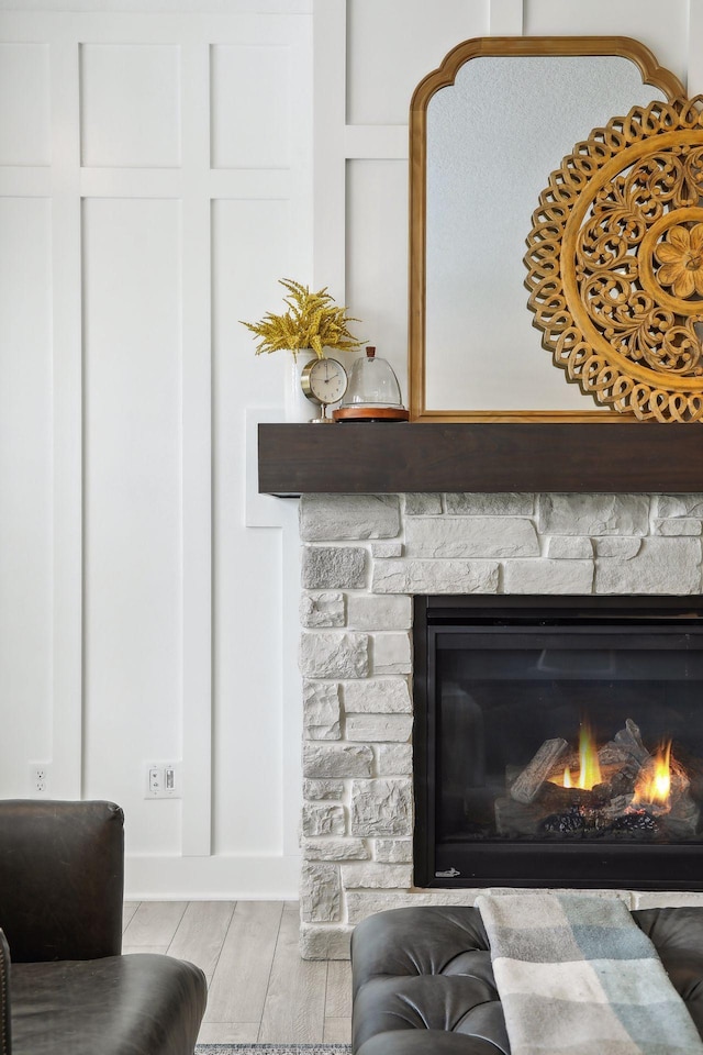 interior details featuring a stone fireplace and wood finished floors