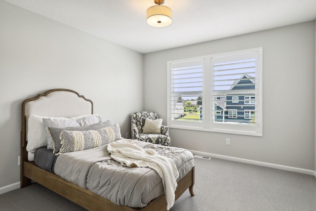 carpeted bedroom featuring visible vents and baseboards