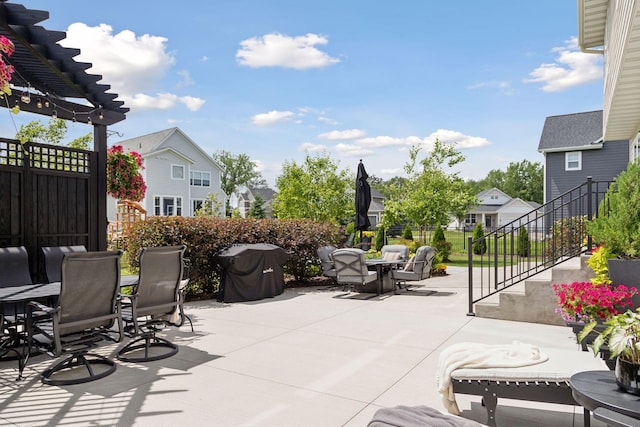 view of patio with a residential view, fence, outdoor dining area, and a pergola