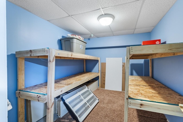 carpeted bedroom with a drop ceiling