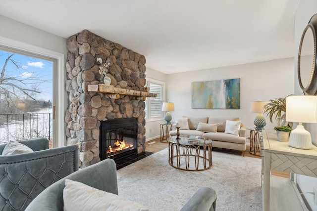 living room featuring hardwood / wood-style flooring and a stone fireplace