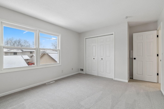 unfurnished bedroom with a closet and light colored carpet