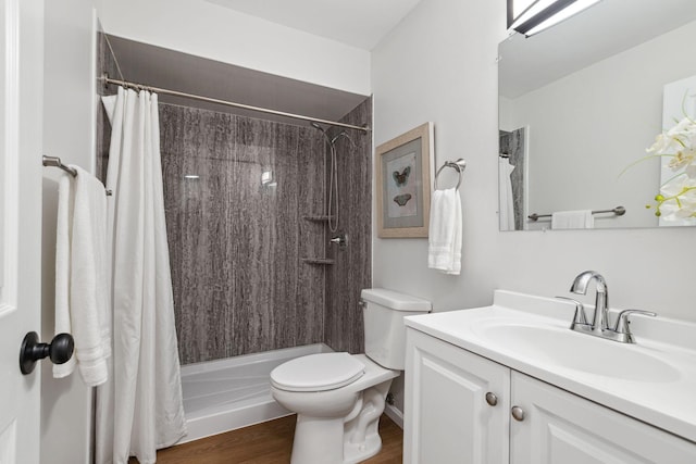 bathroom with hardwood / wood-style flooring, toilet, a shower with shower curtain, and vanity