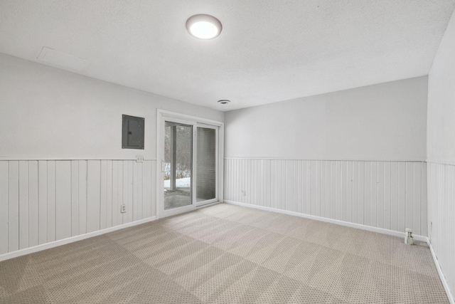 unfurnished room featuring light colored carpet and electric panel