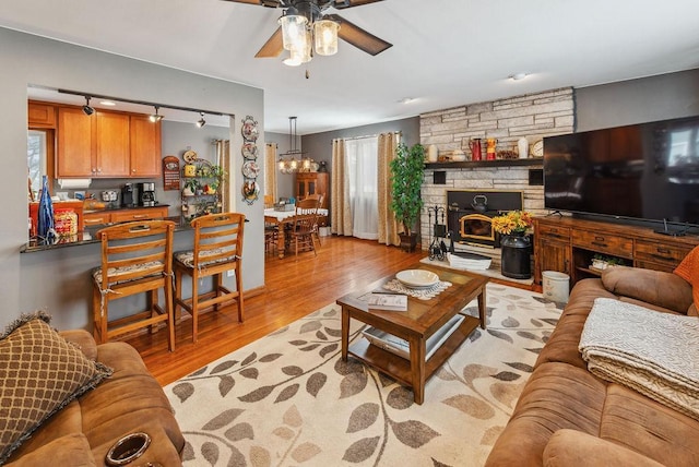 living room featuring light wood-type flooring and ceiling fan with notable chandelier