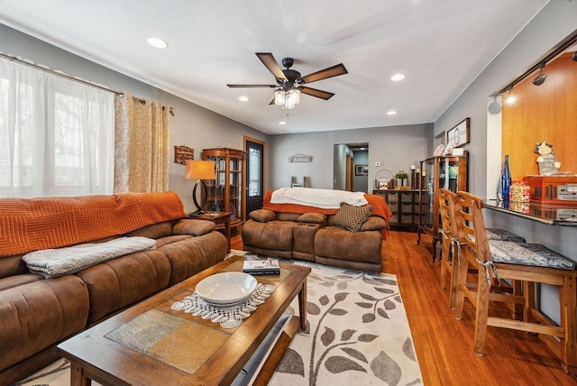 living area with light wood-style flooring, ceiling fan, and recessed lighting