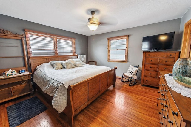 bedroom featuring light wood finished floors, ceiling fan, and multiple windows