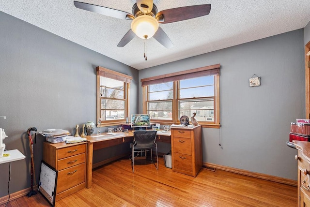 office area featuring a ceiling fan, baseboards, a textured ceiling, and light wood finished floors