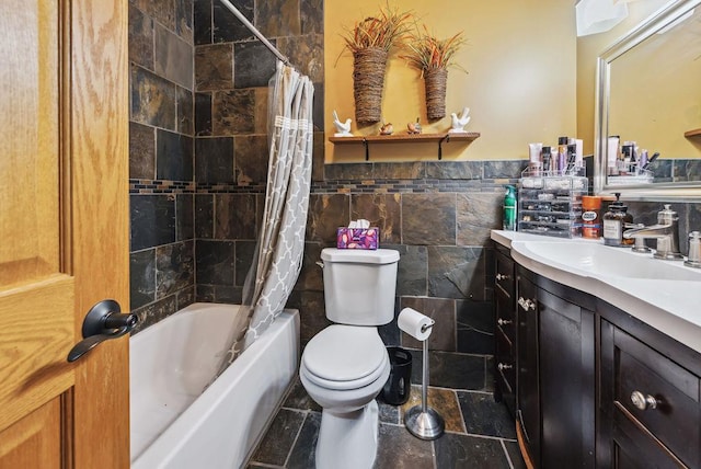 bathroom with shower / tub combo, stone tile floors, toilet, vanity, and tile walls