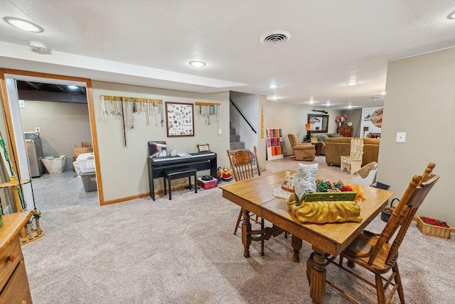 dining space featuring washer / clothes dryer, visible vents, stairway, light carpet, and baseboards