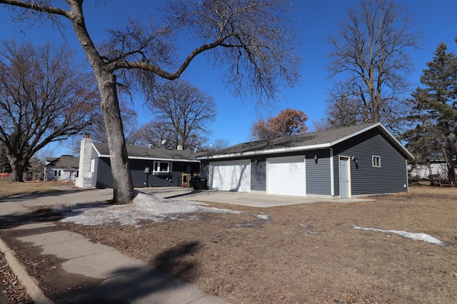 single story home with a garage and a chimney