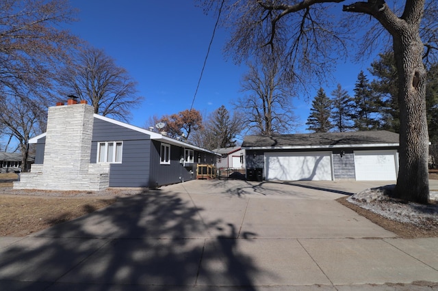 view of home's exterior featuring a garage, stone siding, and a chimney