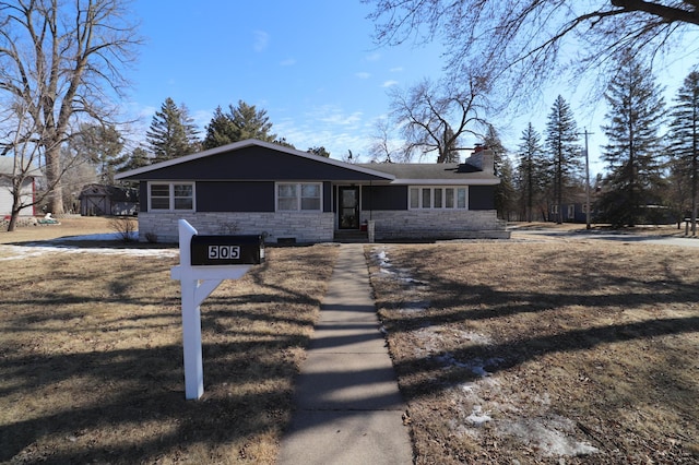 view of front of house with stone siding and a chimney