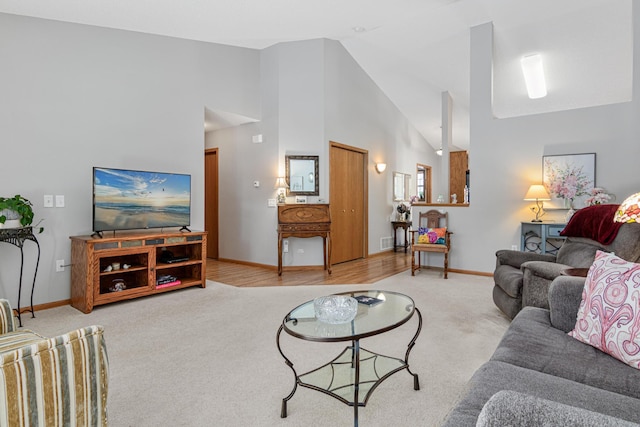 living room featuring high vaulted ceiling and carpet floors