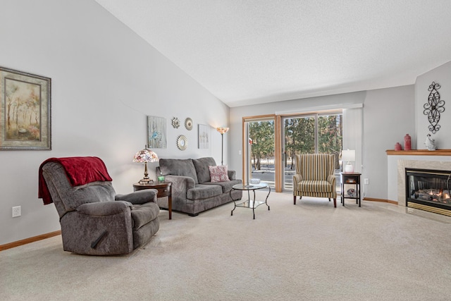 carpeted living room featuring lofted ceiling and a tiled fireplace