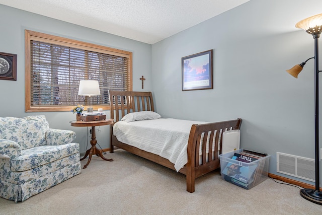 bedroom with carpet floors and a textured ceiling