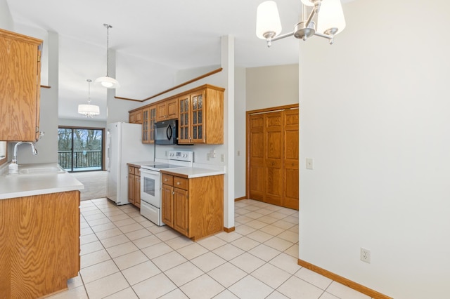 kitchen with white appliances, sink, pendant lighting, a notable chandelier, and lofted ceiling