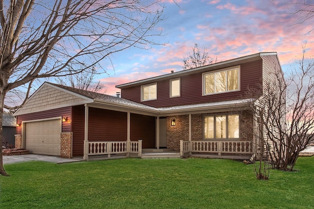 view of front of home featuring a garage, a yard, and a porch