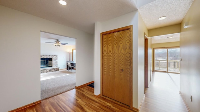 hall with hardwood / wood-style floors and a textured ceiling