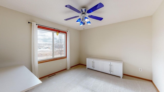 empty room featuring ceiling fan and light carpet