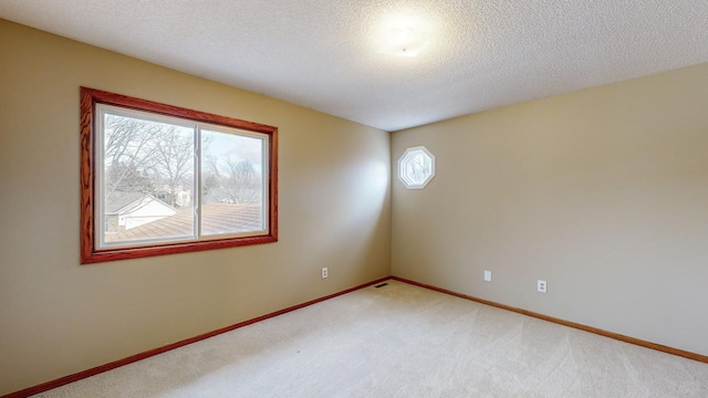 carpeted empty room with a textured ceiling