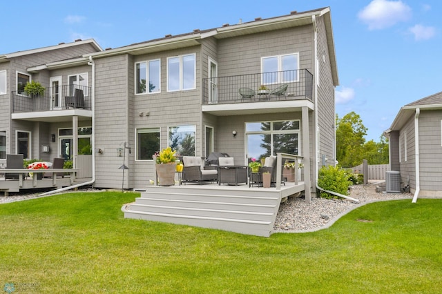 rear view of property featuring a balcony, central AC unit, a yard, and an outdoor living space