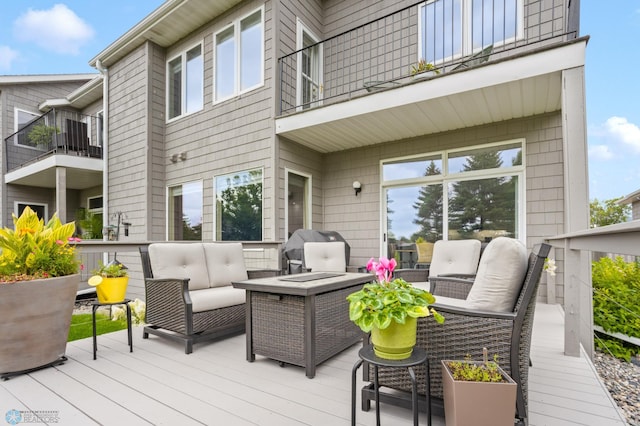 deck featuring an outdoor living space with a fire pit