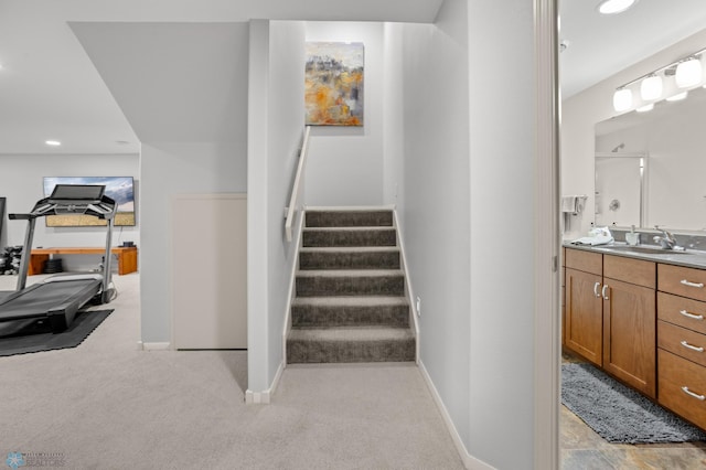 stairway with sink and carpet flooring