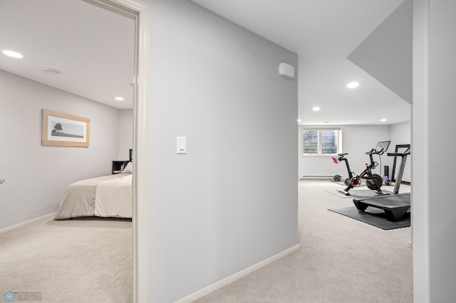 hallway featuring a baseboard heating unit and light carpet