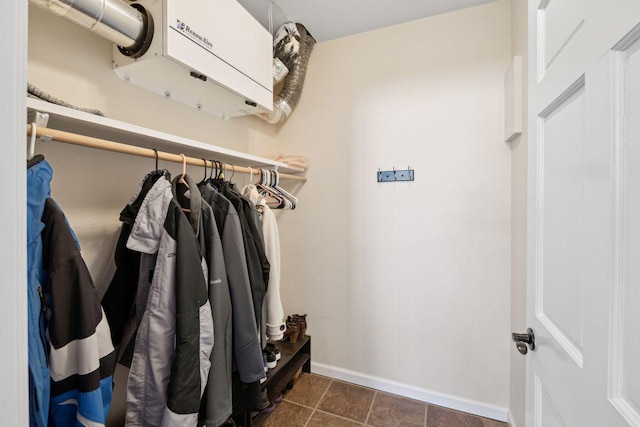 spacious closet with dark tile patterned floors