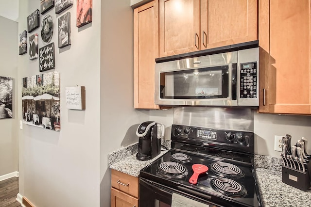 kitchen featuring black / electric stove, light stone countertops, and dark hardwood / wood-style floors