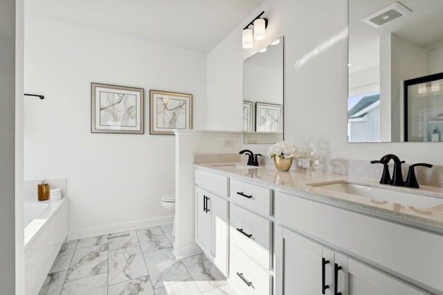 bathroom featuring vanity, toilet, and a tub to relax in