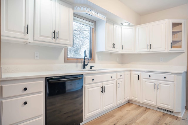 kitchen with sink, white cabinetry, light hardwood / wood-style floors, and black dishwasher